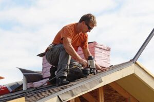 Two people examining a newly installed shingle roof on a single-family home from the lawn below.